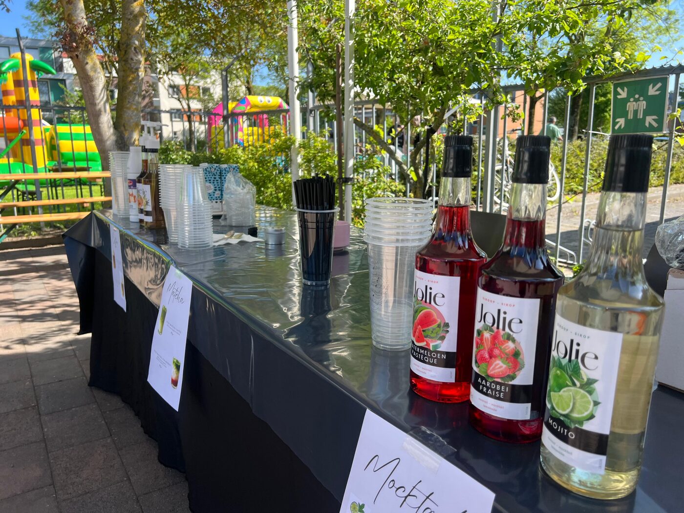 Flessen siroop en bekers op de mocktailbar, met het springkussen op de achtergrond